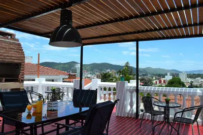a patio with a table and chairs on a deck at Atenea in Villa Carlos Paz