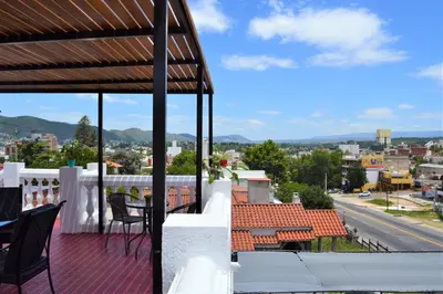 a balcony with chairs and a view of a city at Atenea in Villa Carlos Paz