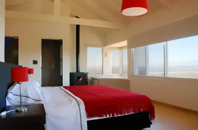a bedroom with a bed with a red blanket at La Fleur in Villa General Belgrano