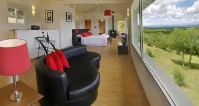 a room with a couch and a bed and a bedroom at La Fleur in Villa General Belgrano