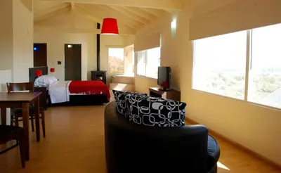 a hotel room with a bed and a couch and a table at La Fleur in Villa General Belgrano