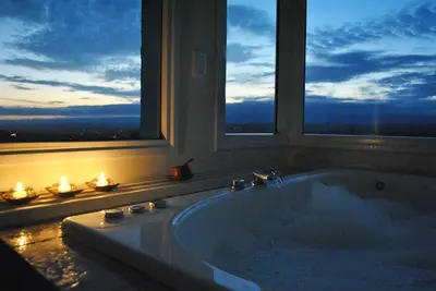 a bath tub in a bathroom with two windows at La Fleur in Villa General Belgrano