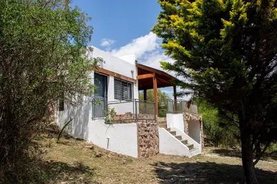 a house with a staircase in the middle of trees at Cuesta los Robles -Casas Serranas- in Villa Icho Cruz