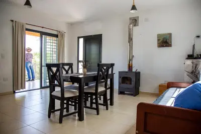 a dining room with a table and chairs and a fireplace at Cuesta los Robles -Casas Serranas- in Villa Icho Cruz