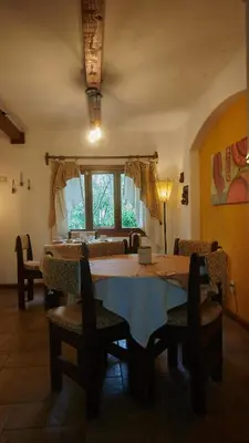 a dining room with a table and chairs and a window at Posada Aitue in Villa General Belgrano