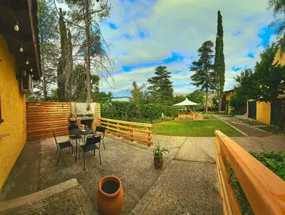 a patio with a table and chairs and a fence at Posada Aitue in Villa General Belgrano