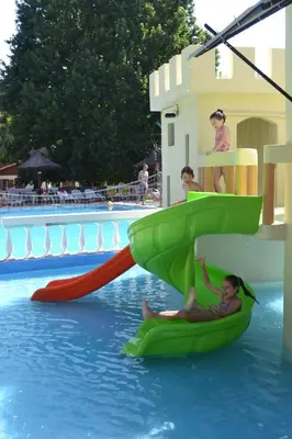 a man and two children are riding on a raft in a pool at Cabañas Alpendorf in Villa General Belgrano