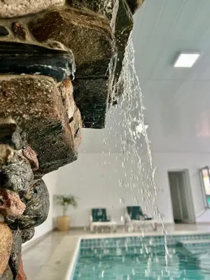 a swimming pool in a house with a waterfall at Cabañas Alpendorf in Villa General Belgrano