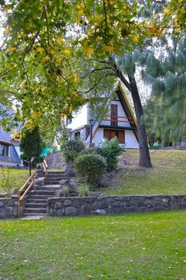 a person sitting on stairs in front of a house at Cabañas Alpendorf in Villa General Belgrano