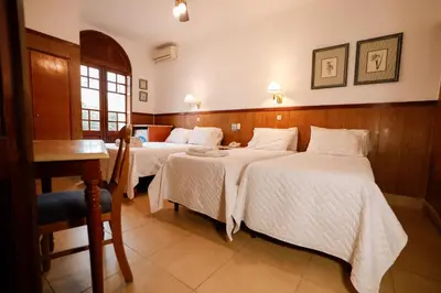 a hotel room with two beds and a desk at Cordoba Yolanda Hotel in Cordoba