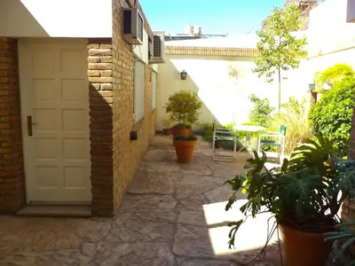a patio with a white door and a table and plants at Cordoba Yolanda Hotel in Cordoba