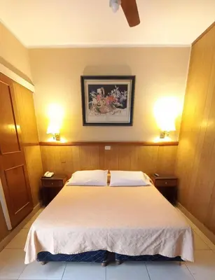 a bedroom with a large bed with two lamps at Cordoba Yolanda Hotel in Cordoba