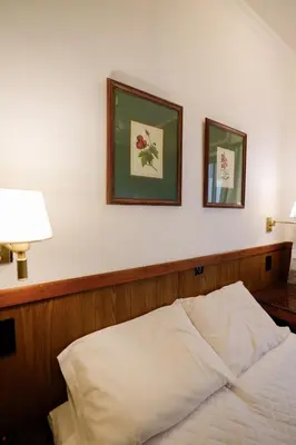 a bed in a room with two pictures on the wall at Cordoba Yolanda Hotel in Cordoba