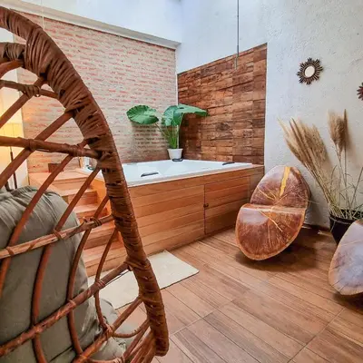 a bathroom with a bath tub and a wooden floor at Posada Mia Nonna in Villa General Belgrano