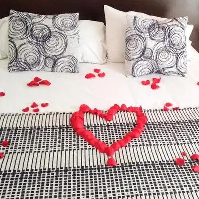 a bed with red hearts and pillows on it at Posada Mia Nonna in Villa General Belgrano