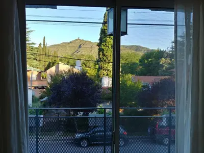 a window with a view of a car parked in a yard at Posada Mia Nonna in Villa General Belgrano