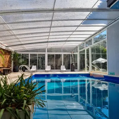 an indoor swimming pool with a ceiling and windows at Posada Mia Nonna in Villa General Belgrano