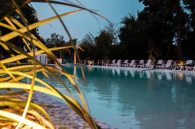 a swimming pool with lawn chairs and water at Parque Hotel in Villa Carlos Paz