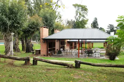 a house with a fence in front of it at Parque Hotel in Villa Carlos Paz