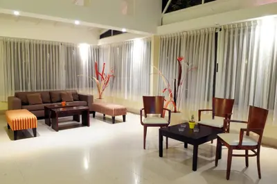 a living room with a couch and tables and chairs at Parque Hotel in Villa Carlos Paz