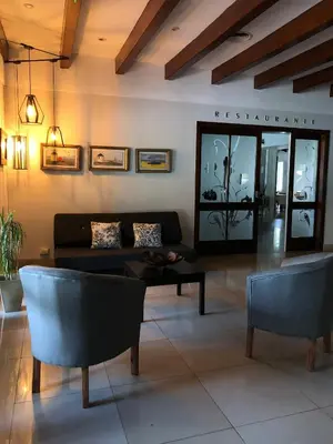 a living room with a couch and a table and chairs at Parque Hotel in Villa Carlos Paz
