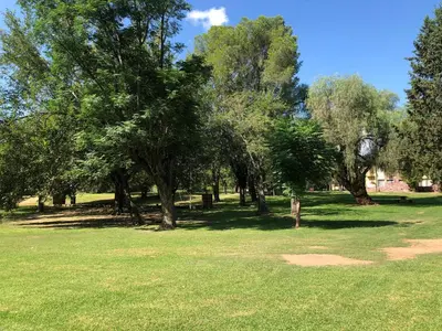 a park with trees and a field with green grass at Parque Hotel in Villa Carlos Paz
