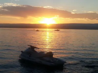 a boat in the water with the sunset in the background at Casa Loft Rumipal in Villa Rumipal