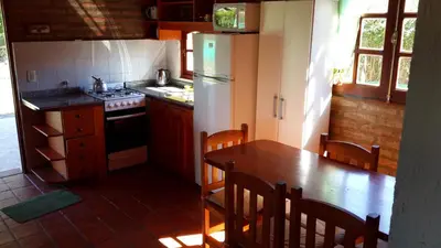 a kitchen with a table and a refrigerator at Casa Loft Rumipal in Villa Rumipal