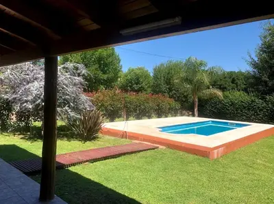 a swimming pool in a yard with a grass field at Casa Loft Rumipal in Villa Rumipal