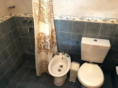 a bathroom with a toilet and a shower curtain at Casa Loft Rumipal in Villa Rumipal