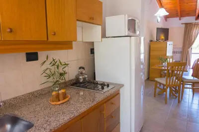 a kitchen with a white refrigerator and a counter top at Candy Apart Hotel in Villa General Belgrano