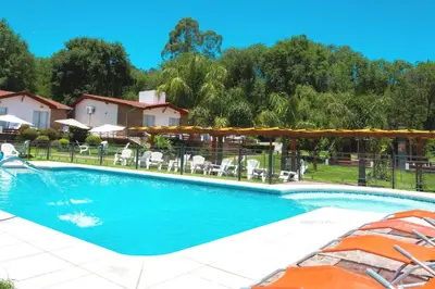 a swimming pool with a fountain in a yard at Candy Apart Hotel in Villa General Belgrano
