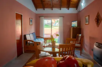 a kitchen and dining room with a table and tomatoes at Candy Apart Hotel in Villa General Belgrano