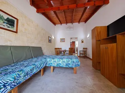a living room with a bed and a tv at Candy Apart Hotel in Villa General Belgrano