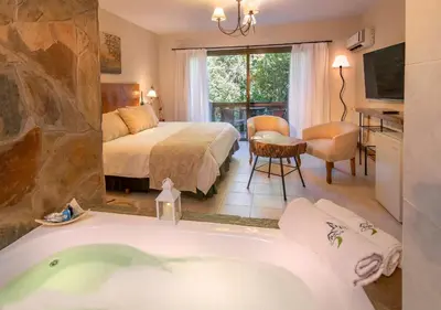 a bathroom with a bed and a tub in a room at Posada del Sauce in Villa General Belgrano