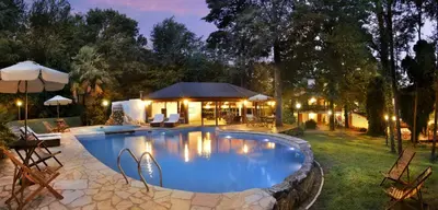 a swimming pool in a yard with a house at Posada del Sauce in Villa General Belgrano
