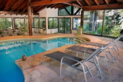 a swimming pool with chairs in a house at Posada del Sauce in Villa General Belgrano
