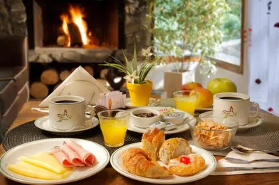 a table topped with plates of food and cups of coffee at Posada del Sauce in Villa General Belgrano