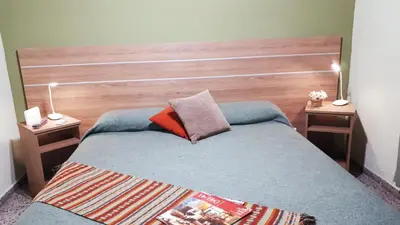 a bedroom with a bed with a wooden headboard at Hotel Mirador de las Sierras in Villa Carlos Paz