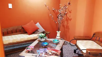 a living room with two beds and a coffee table at Hotel Mirador de las Sierras in Villa Carlos Paz