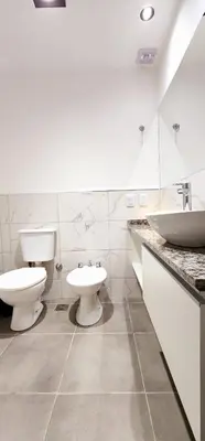 a bathroom with two toilets and a sink at Hotel Mirador de las Sierras in Villa Carlos Paz