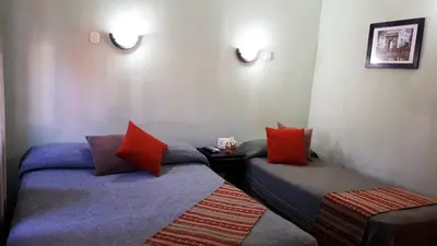 two beds in a room with red and blue pillows at Hotel Mirador de las Sierras in Villa Carlos Paz