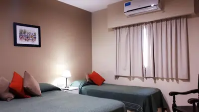 a hotel room with two beds and a window at Hotel Mirador de las Sierras in Villa Carlos Paz