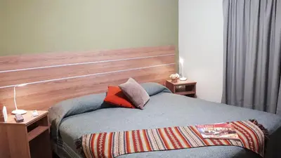 a bedroom with a bed with a wooden headboard at Hotel Mirador de las Sierras in Villa Carlos Paz