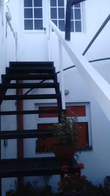 a house with stairs and a potted plant in front of it at La Cima Alta Gracia in Alta Gracia