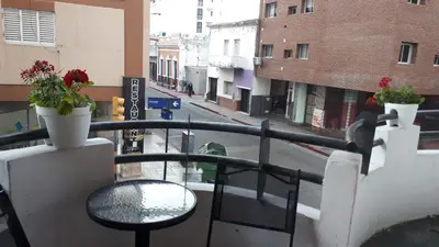 a balcony with a table and flowers on a city street at mi depto en cba in Cordoba