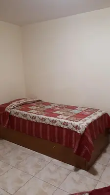 a bed in a room with a red blanket on it at mi depto en cba in Cordoba
