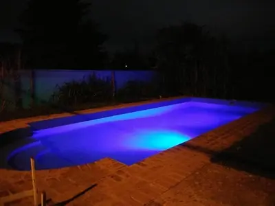 a swimming pool lit up blue at night at Al lado in Cordoba