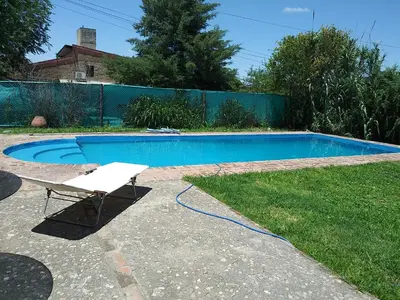 a white chair next to a swimming pool at Al lado in Cordoba