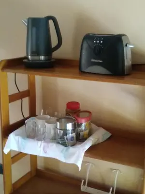 a shelf with pots and pans and a toaster at Al lado in Cordoba